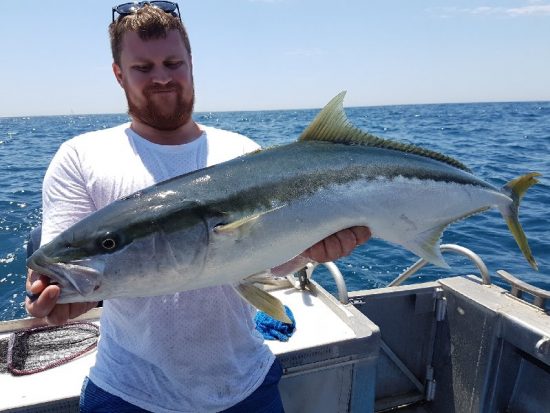 Man and large fish on sport fishing trip with Wahoo Fishing Charters