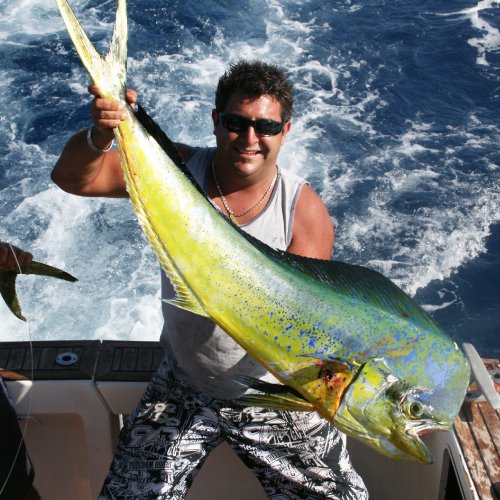 A man has caught a fish with Wahoo Fishing Charters.
